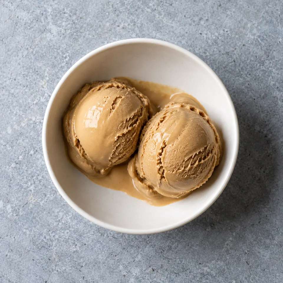 Glace à l'eau au café : deux boules brun clair lisses dans un bol blanc, vue de dessus.