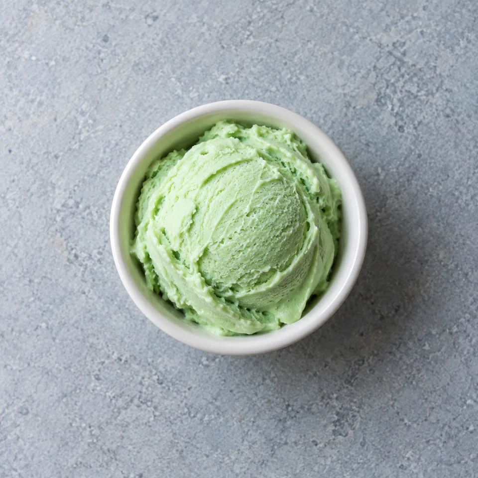 Portion de glace à la menthe maison verte et crémeuse dans un ramequin blanc.