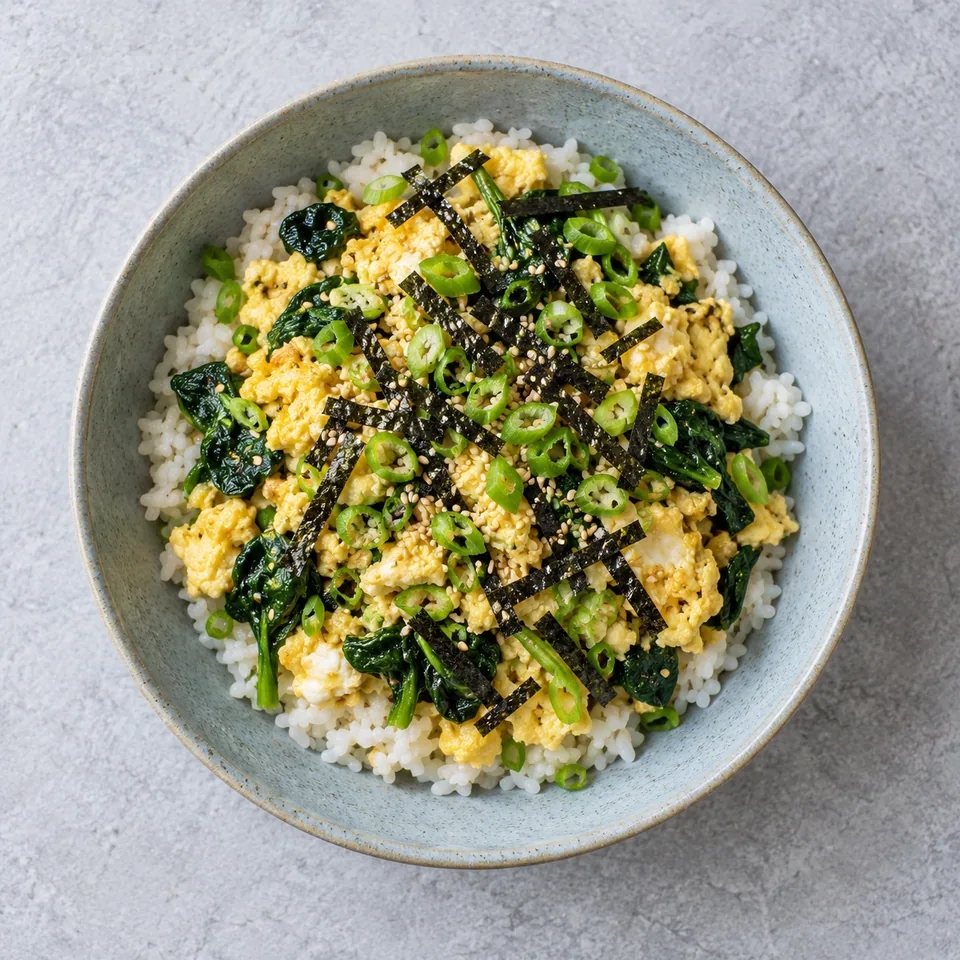 Gyeran bap : riz à l'œuf aux épinards et nori dans une assiette creuse bleu-gris.