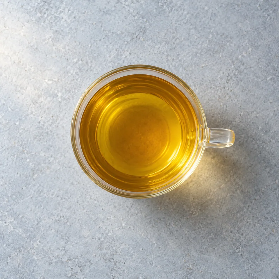 Tasse d'infusion au thé vert aux épices, liquide doré et limpide.