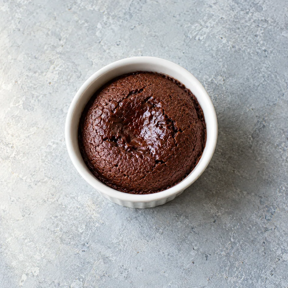 Mi-cuit chocolat au micro-ondes dans un ramequin blanc, surface lisse et brun chocolat.