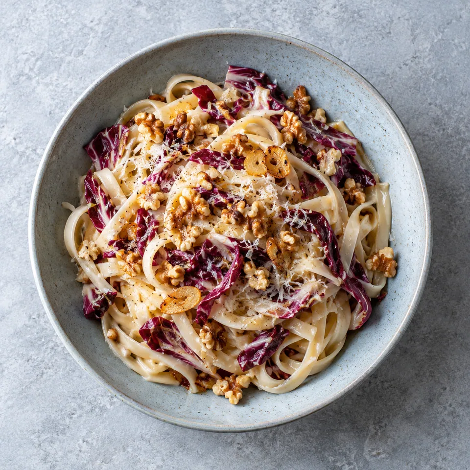 Pâtes au radicchio, noix et fromage végétarien dans une assiette creuse bleu-gris pâle.