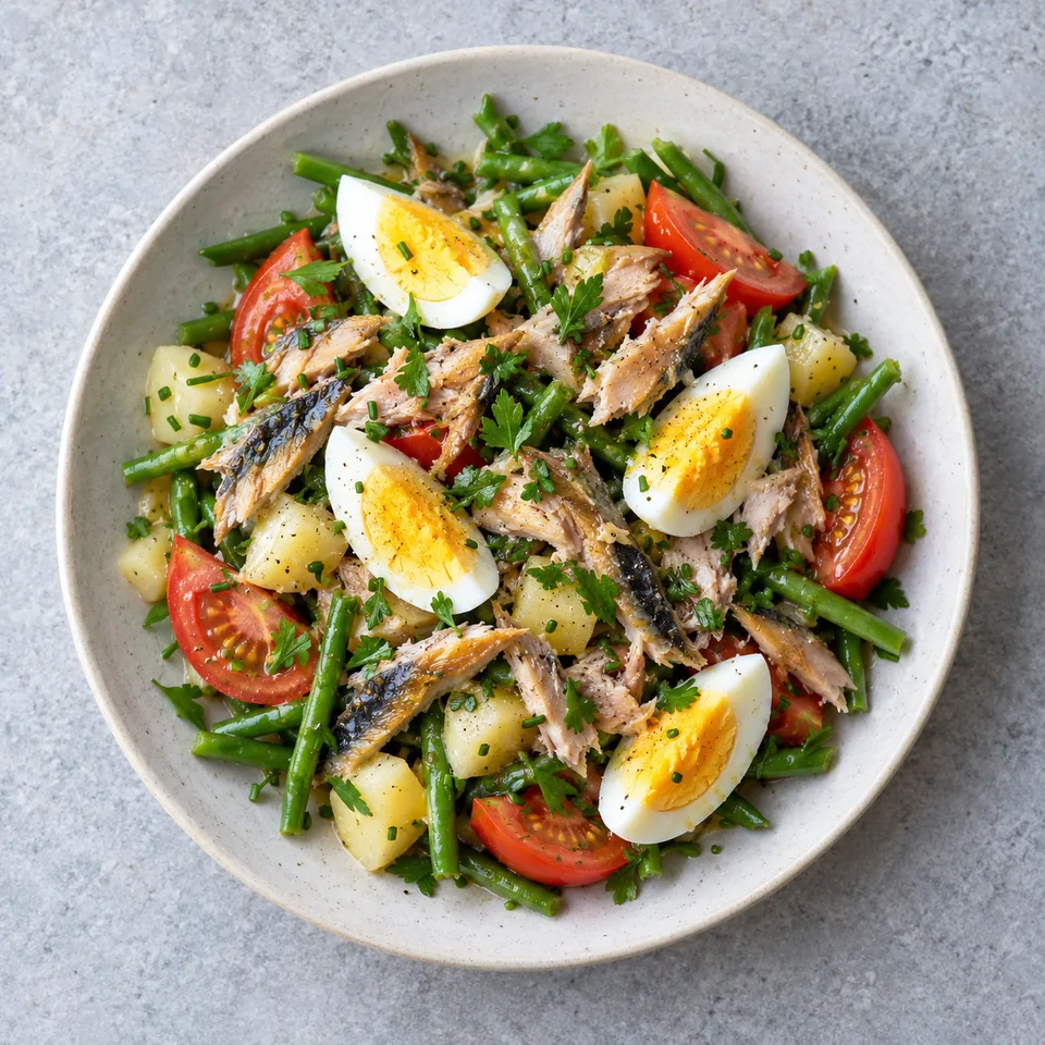Salade de pommes de terre au maquereau : dés de pommes de terre, haricots verts, tomates, poisson émietté et quartiers d’œuf.