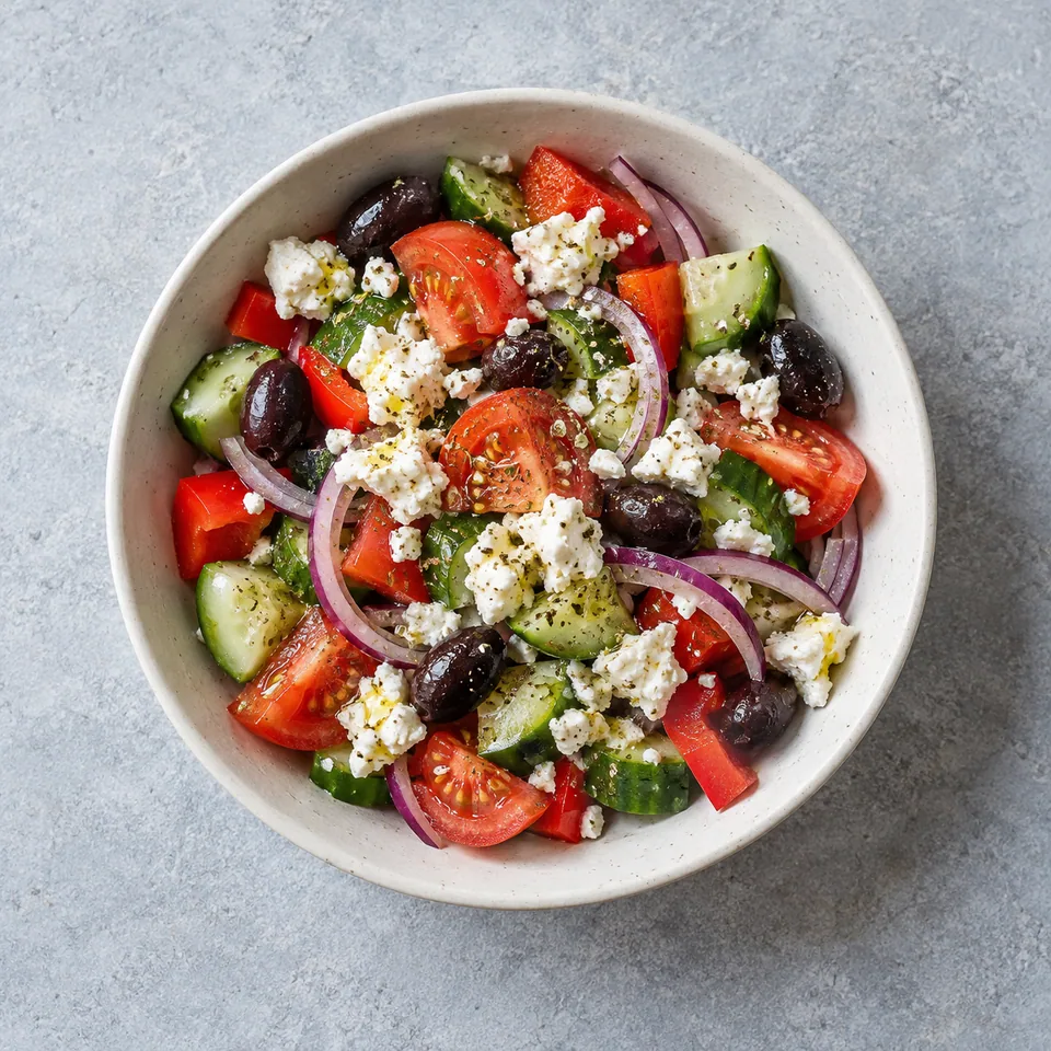 Salade grecque pour une personne, avec tomates, concombre, poivron, oignon rouge, olives noires et feta émiettée.
