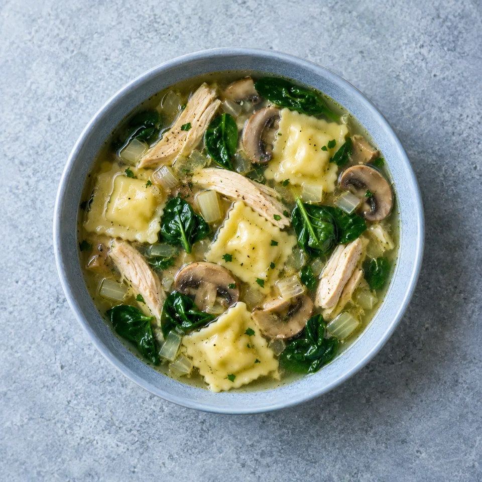 Soupe de ravioles au poulet : bouillon avec poulet en lamelles, ravioles, champignons émincés, épinards et oignon.