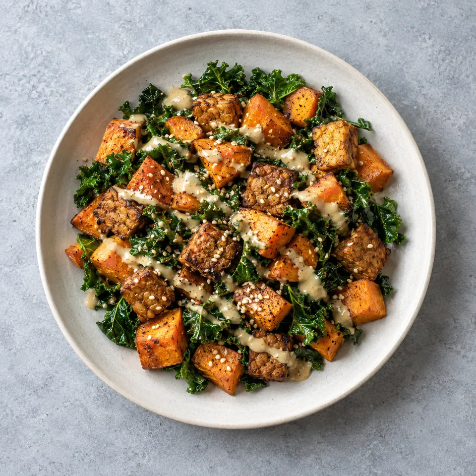 Tempeh croustillant, patate douce et kale : cubes orangés, tempeh doré, kale émincé et sauce beige au sésame.